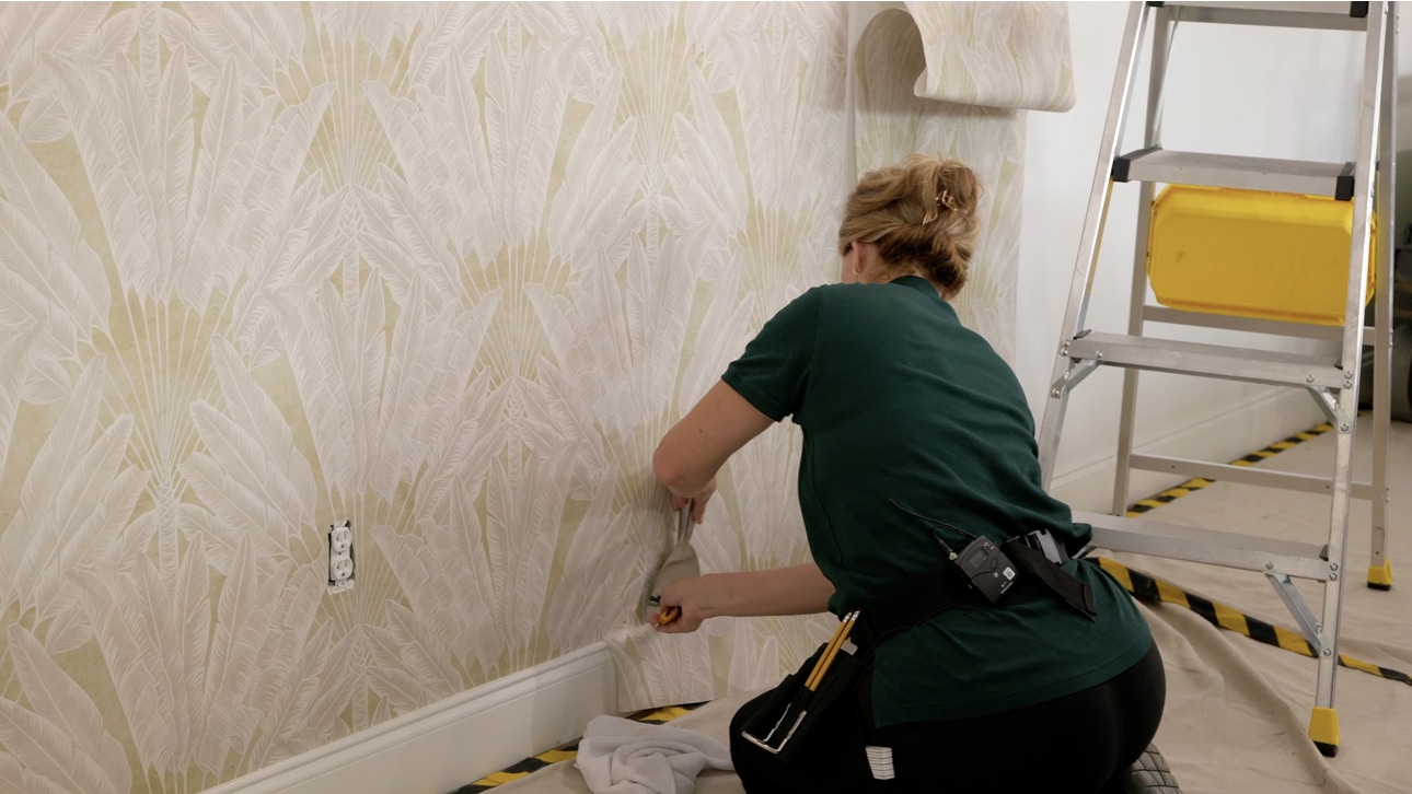 Wallpaper being carefully applied to an interior wall